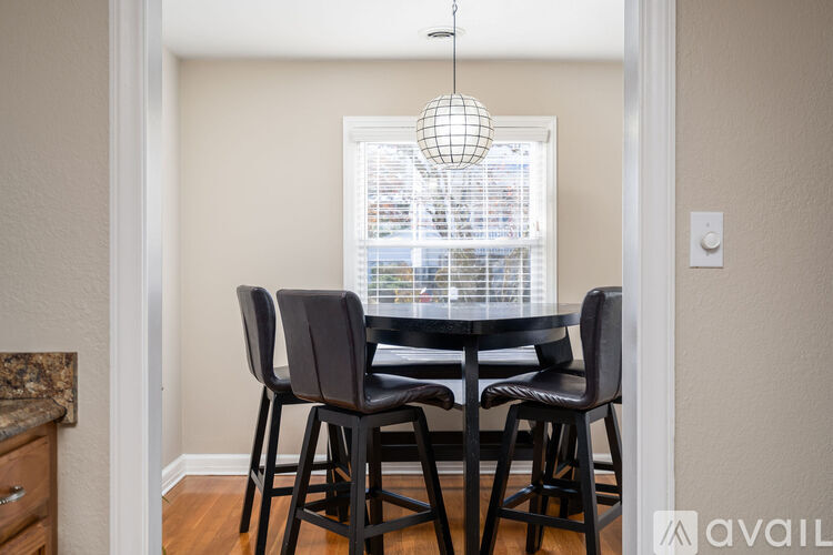 A dining room with a table and chairs.