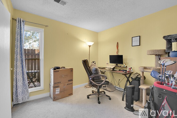 A room with a desk, chair, and computer setup.