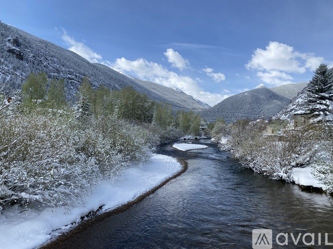 A river flows through a snowy landscape with trees on either side.