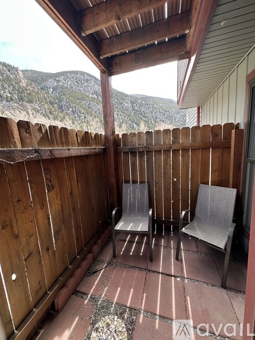 A wooden deck with two chairs and a table.