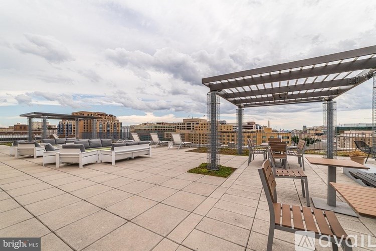 A rooftop patio with a pergola and benches.