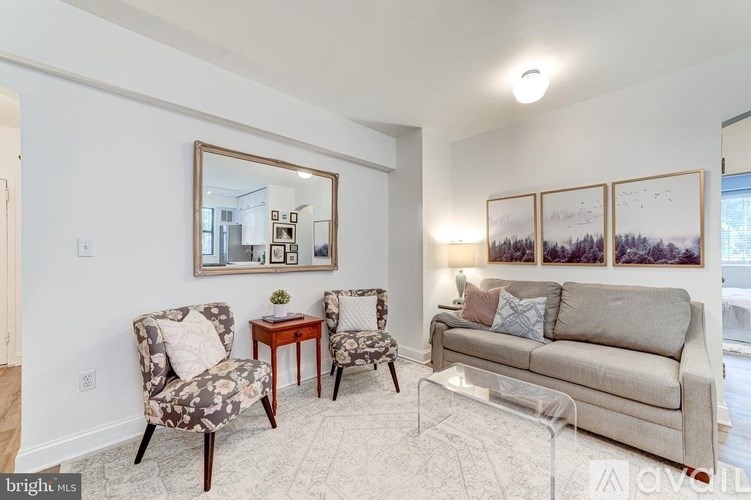 A living room with a couch, two chairs, and a coffee table.