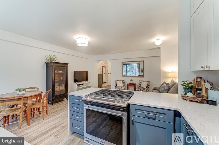 A kitchen with a stove top oven and a dining table.