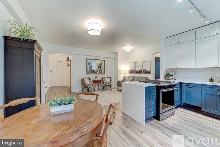 A bright and modern kitchen with blue cabinets and a wooden table.
