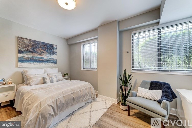 A bedroom with a large bed and a painting on the wall.