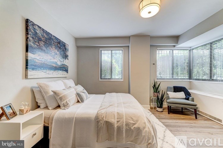 A bedroom with a large bed and a painting on the wall.