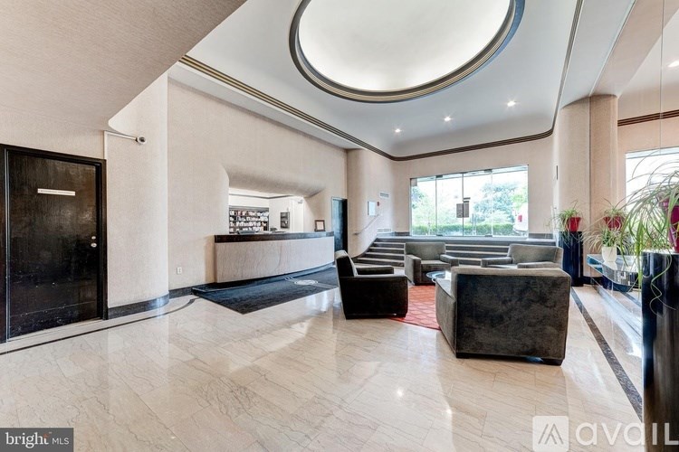 A spacious living room with a curved ceiling and a black door on the left.