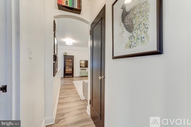 A hallway with a peacock painting on the wall.