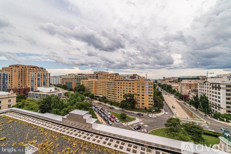 A cityscape with buildings, roads, and a cloudy sky.