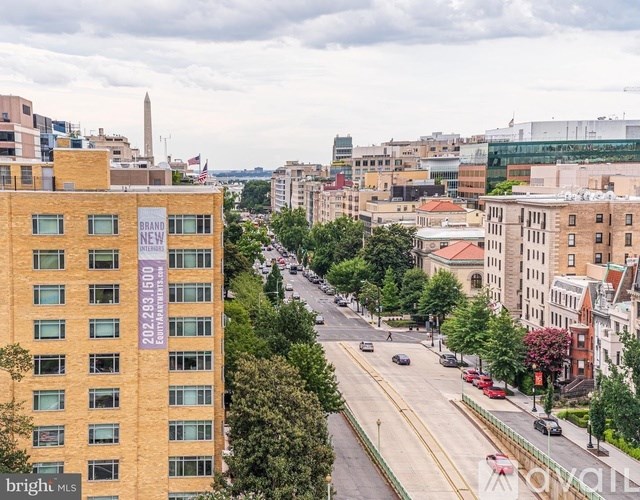 A view of a city street from a high vantage point with a building in the foreground that has a sign that reads "bright MLS".
