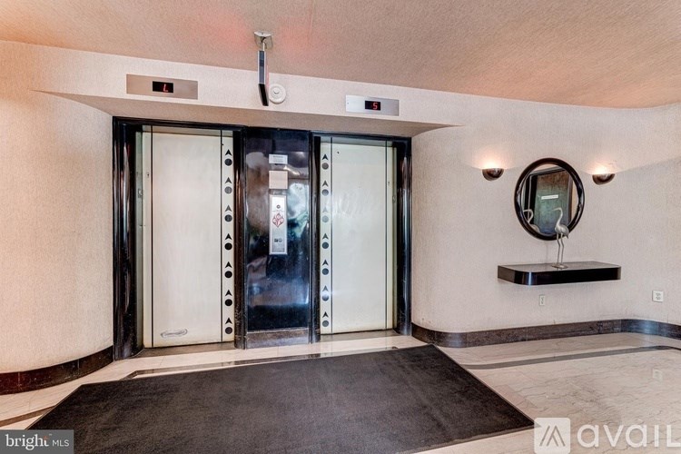 A room with a black carpet and a mirror on the wall.