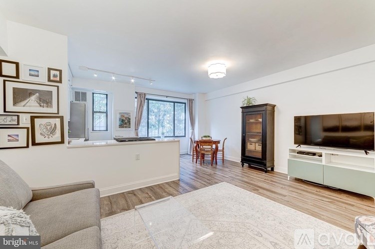 A living room with a grey couch, a wooden table, a television, and a fireplace.
