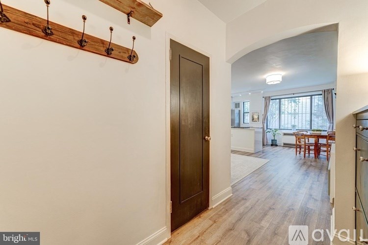 A room with a wooden door and a white wall.