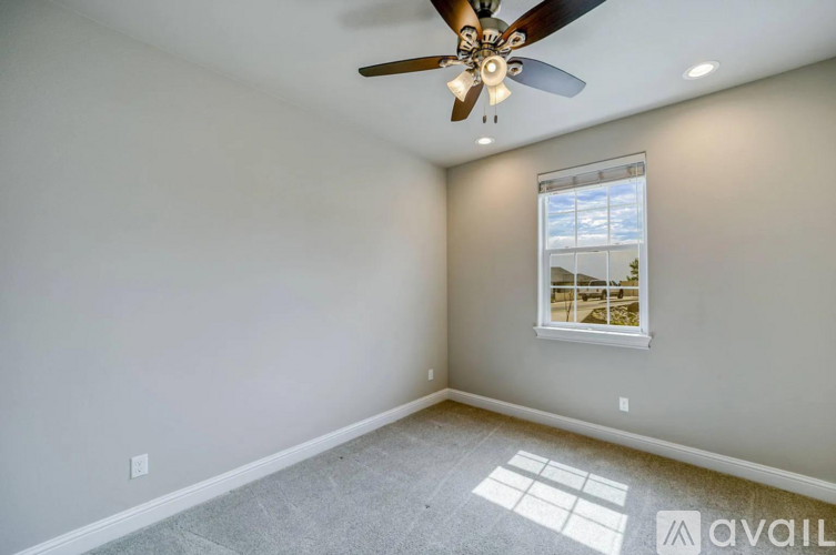 A room with a ceiling fan and a window.
