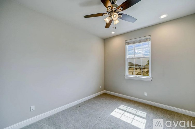 A room with a ceiling fan and a window.