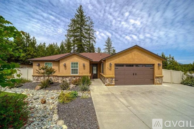 A house with a brown roof and a driveway in front of it.