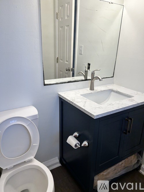 A white toilet sits next to a sink in a bathroom.