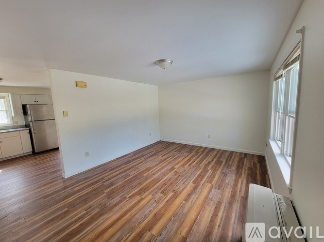 A room with wooden flooring and white walls.
