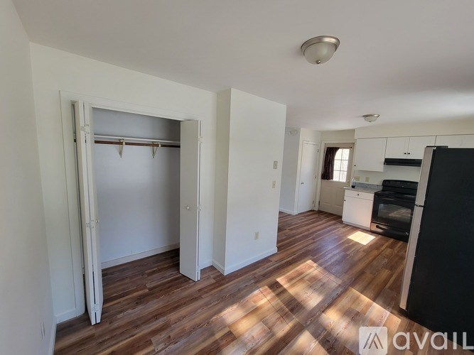 A kitchen area with a black oven and wooden flooring.