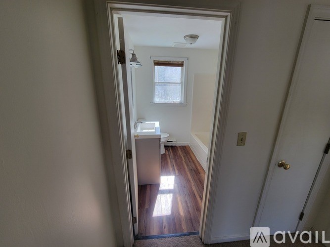 A hallway with a door on the right and a window on the left.