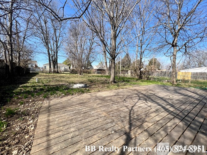 A wooden walkway leads through a grassy area with trees on either side.