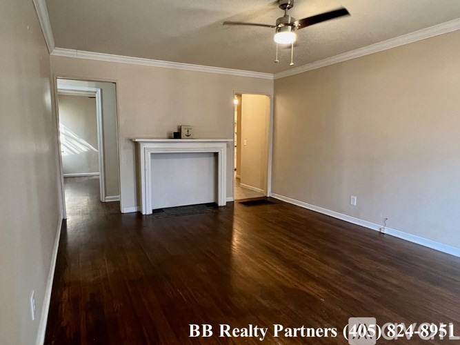 A room with a ceiling fan and a white cabinet.
