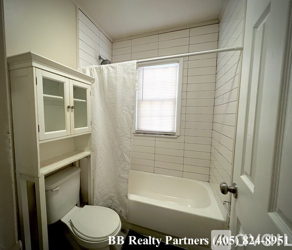 A white bathroom with a toilet, sink, and bathtub.