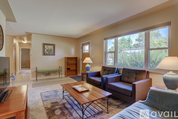 A living room with a brown couch, a coffee table, and a rug.