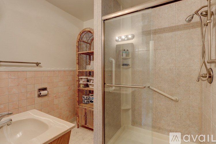 A bathroom with a sink, mirror, and shower.