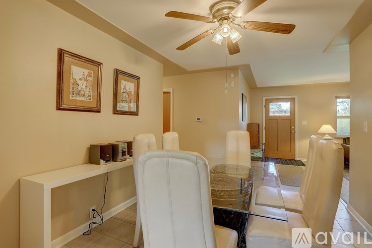 A living room with a white chair and a glass table.