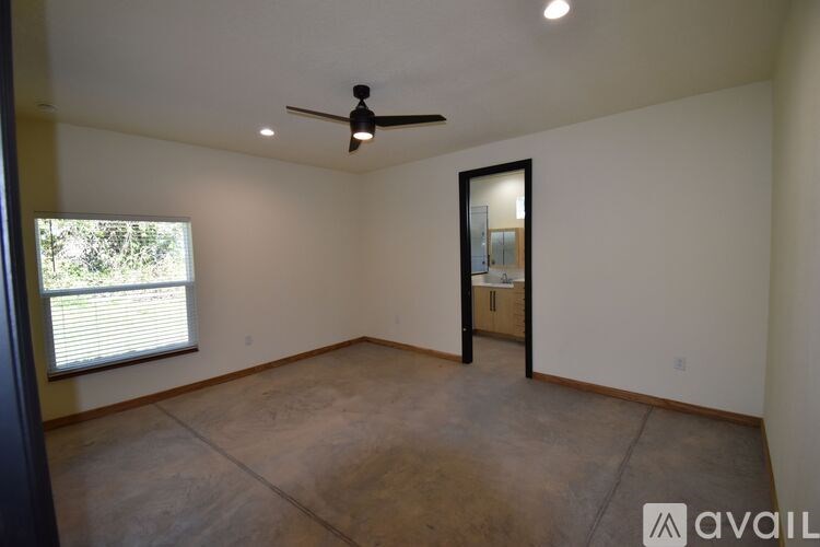 A room with a ceiling fan and a door leading to another room.