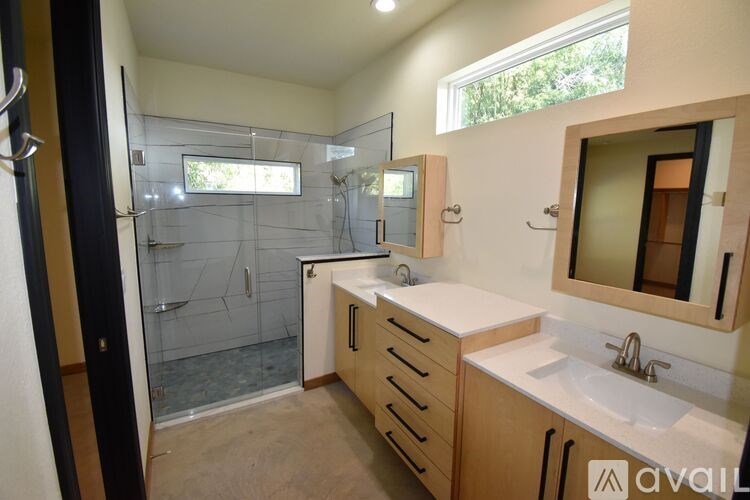 A bathroom with a sink, mirror, and shower.