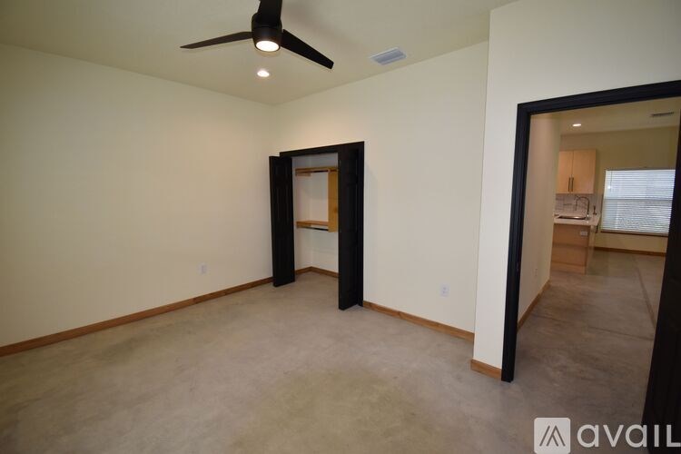 A room with a ceiling fan and a doorway leading to another room.
