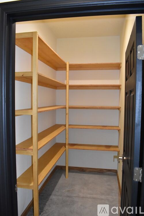 A set of shelves in a room with a black door.