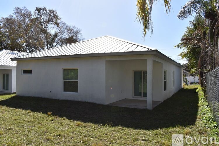 A white house with a metal roof is for sale.