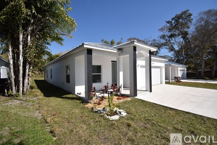 A modern house with a white exterior and a large front yard.