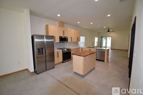 A kitchen with a refrigerator, microwave, oven, and sink is available for rent.