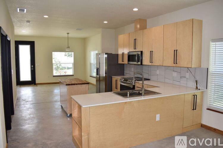 A kitchen with wooden cabinets and a black refrigerator.