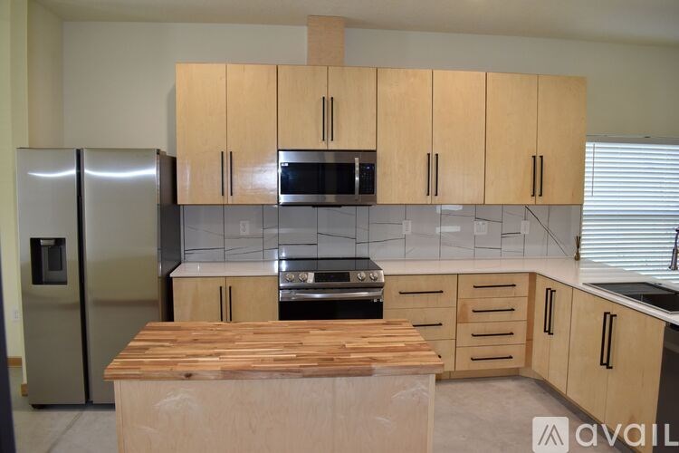 A kitchen with wooden cabinets and a wooden island.