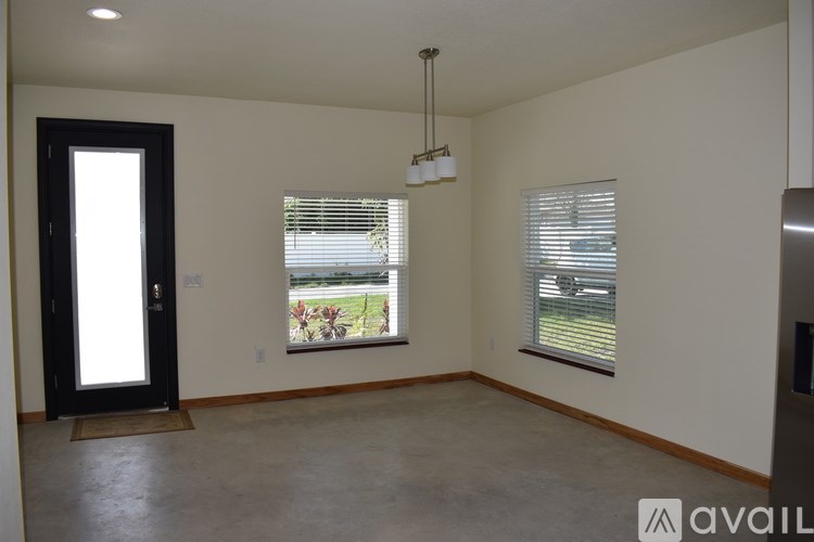 A room with a door, a window, and a hanging light fixture.