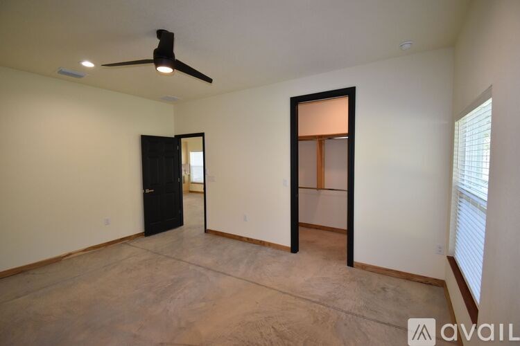 A room with a black door and a ceiling fan.