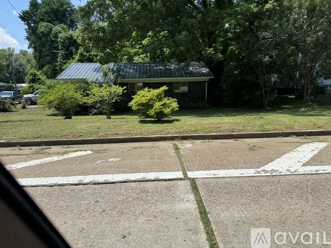 A house with a green lawn and a tree in front of it.