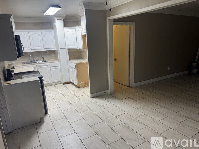 A kitchen with white cabinets and a refrigerator.