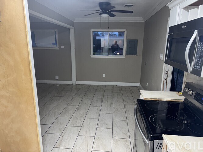 A kitchen with a black stove top oven and a black microwave.