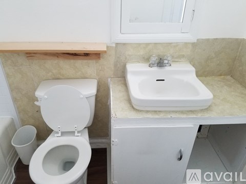 A white toilet and sink in a small bathroom.