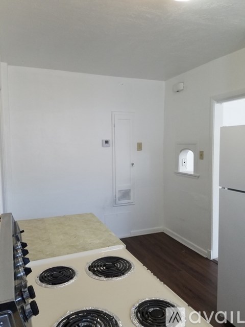 A kitchen with a stove top oven and a refrigerator.