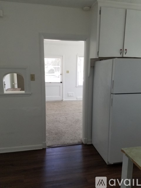 A kitchen area with a refrigerator and cupboards.
