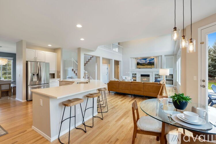 A modern kitchen with a bar area and a dining table set for two.