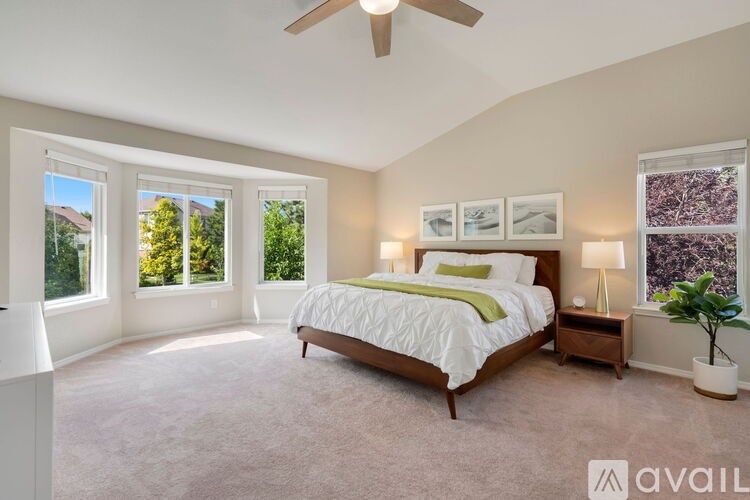 A bedroom with a large bed and a ceiling fan.