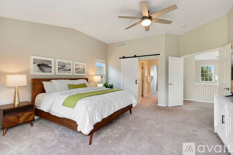 A bedroom with a large bed and a ceiling fan.